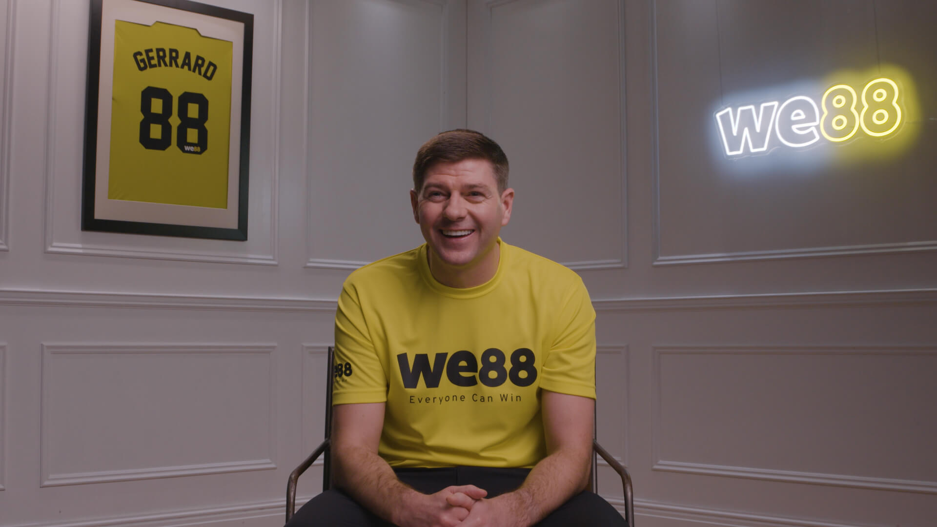 Behind the scenes with WE88 26/27 Global Brand Ambassador Steven Gerrard smiling in his official we88 yellow jersey