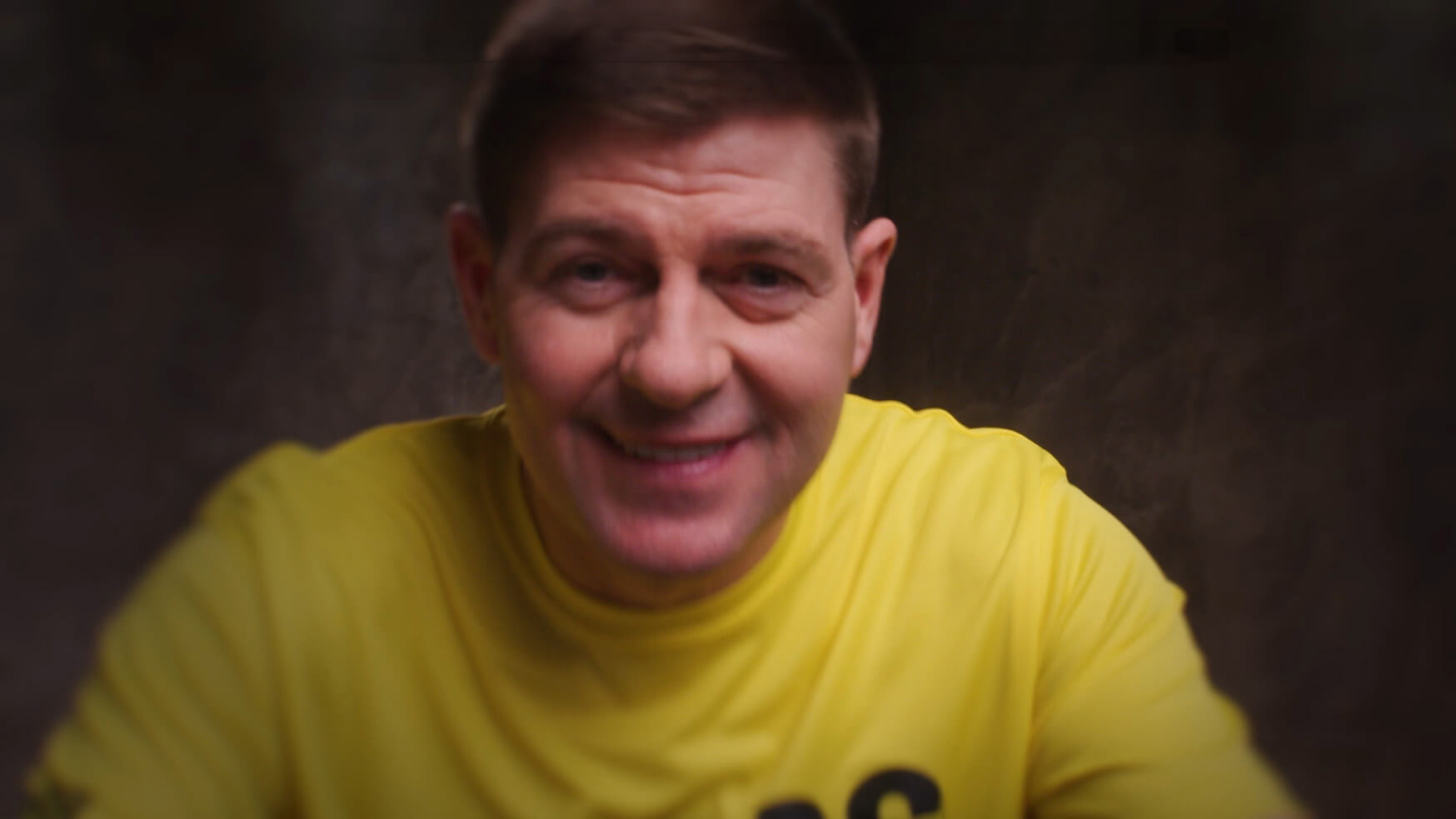 WE88 26/27 Global Brand Ambassador Steven Gerrard leaning towards the camera and ready for a signature for a close-up smile during his studio photoshoot