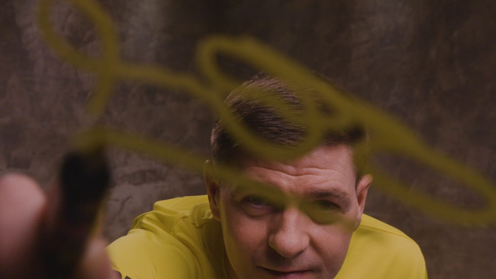 WE88 26/27 Global Brand Ambassador Steven Gerrard signing his autograph on a glass screen during a creative behind-the-scenes shoot